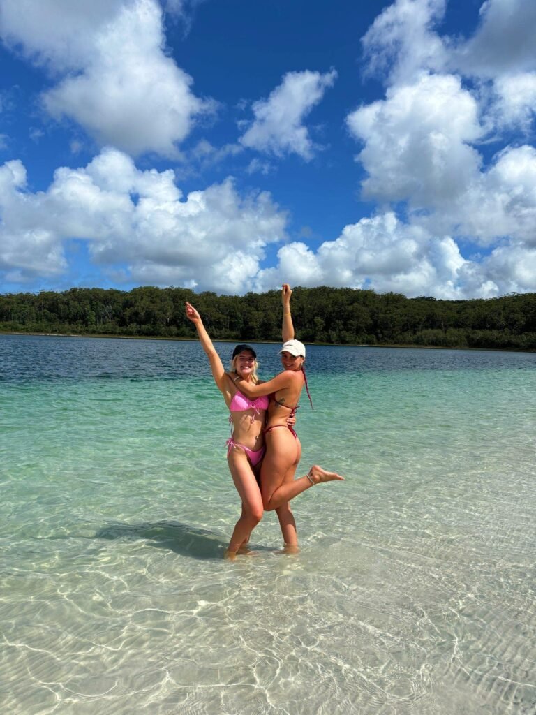 Two backpackers hugging each other as they pose in the middle of the lake on Fraser Island.