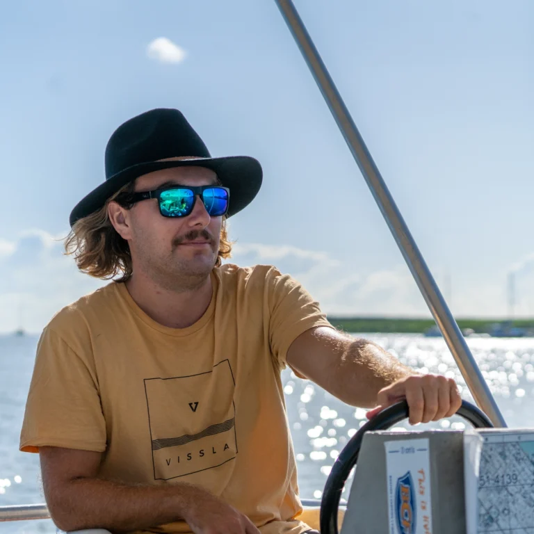 Close up shot of a person driving his private boat hire in Cairns.