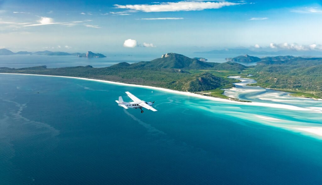 Aerial shot of a plane gliding amongst the Whitsunday islands.