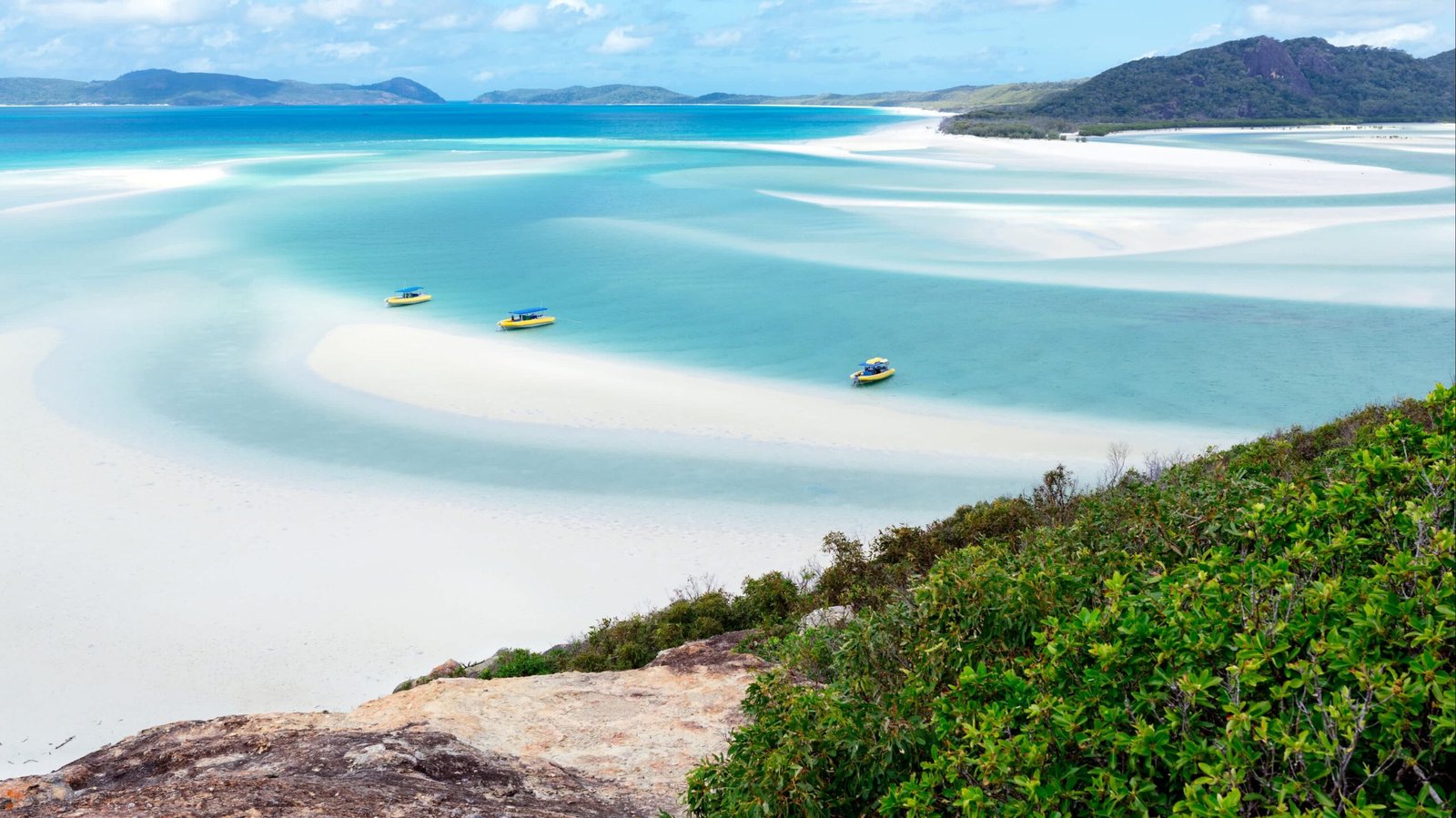 Aerial view of the Whitsundays with boats parked at the beach