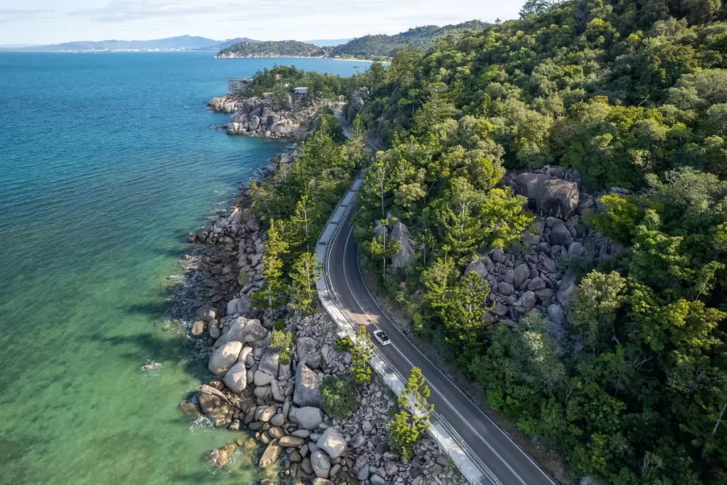 Aerial view of the road for the Great Barrier Reef Drive, hugging the coast and the rainforest.