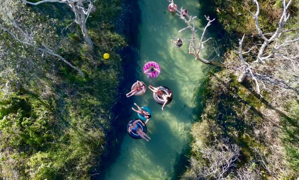 Aerial shot of backpackers tubing down a river on their East Coast Australia Tours
