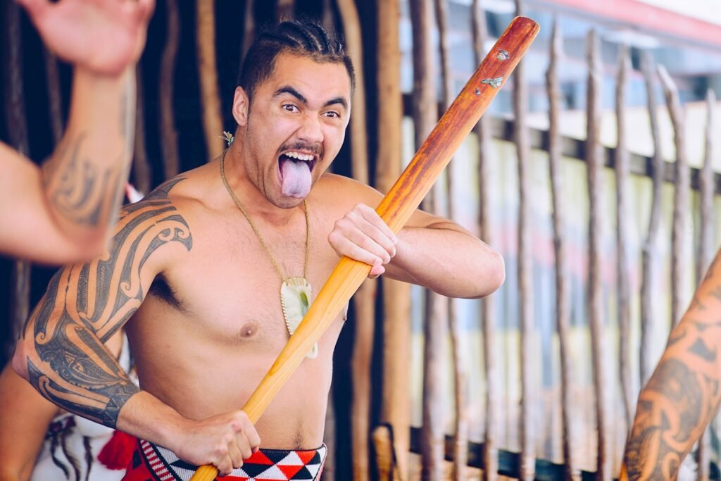 A maori person performing a traditional dance on a New Zealand group tour.