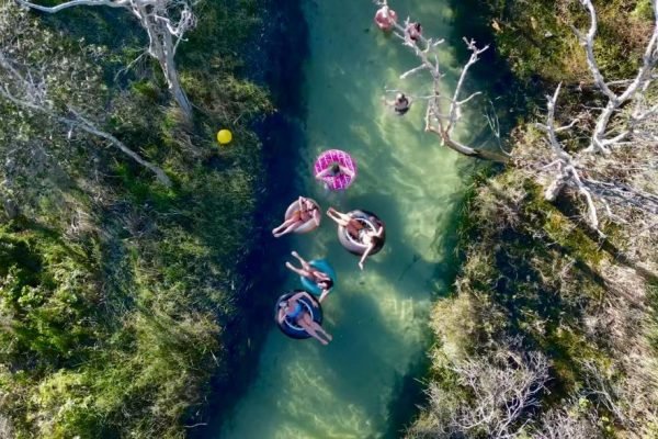 Aerial shot of backpackers tubing down a river on their East Coast Australia Tours